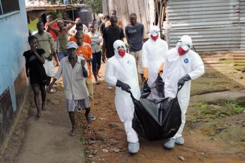 Health workers remove the body of Prince Nyentee, a 29-year-old man whom local residents said died of Ebola virus in Monrovia, September 11, 2014. PHOTO BY REUTERS/James Giahyue