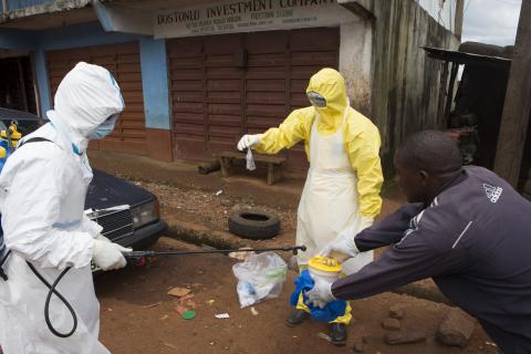 Health workers in protective equipment handle a sample taken from the body of someone who is suspected to have died from Ebola virus, near Rokupa Hospital, Freetown, October 6, 2014. PHOTO BY REUTERS/Christopher Black