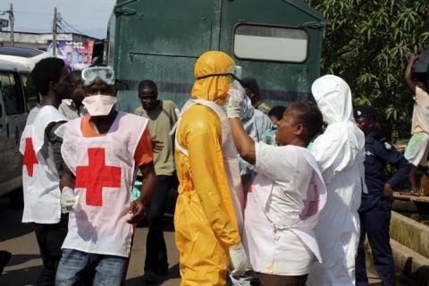 A health worker fixes another health worker's protective suit in the Aberdeen district of Freetown, Sierra Leone, October 14, 2014. PHOTO BY REUTERS/Josephus Olu-Mammah