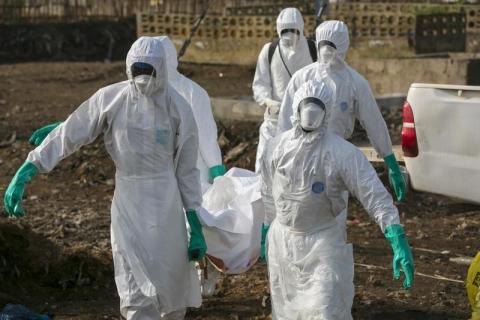 Health workers carry the body of a suspected Ebola victim for burial at a cemetery in Freetown, December 21, 2014. PHOTO BY REUTERS/Baz Ratner