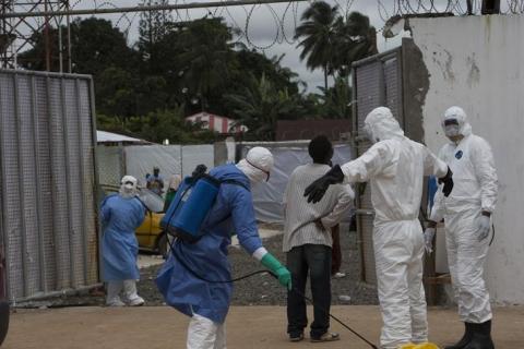 Health workers wearing protective equipment are disinfected outside the Island Clinic in Monrovia, September 30, 2014, where patients are treated for Ebola. PHOTO BY REUTERS/Christopher Black