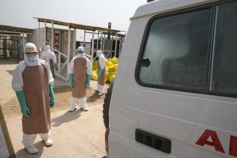 Healthcare workers prepare to disinfect an ambulance transporting a newly admitted Ebola patient at the entrance to the Save the Children Kerry Town Ebola treatment centre outside Freetown, Sierra Leone, December 22, 2014. PHOTO BY REUTERS/Baz Ratner