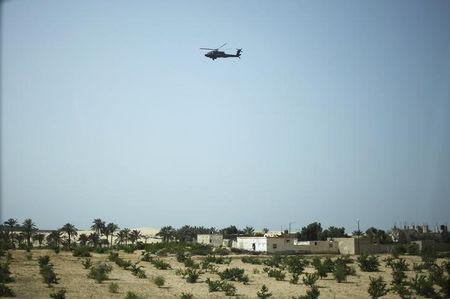 A military helicopter conducts an aerial patrol above Sheikh Zuwayed city, northern Sinai, May 25, 2015. PHOTO BY REUTERS/Asmaa Waguih