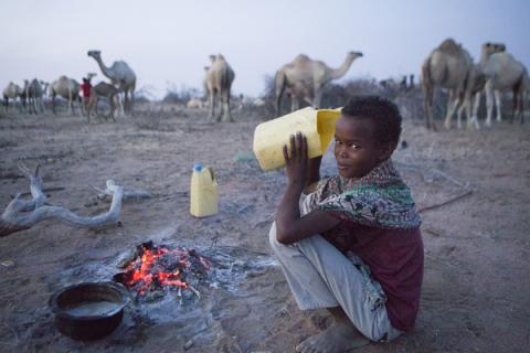 A young camel herder drinks camel milk at dawn in the desert in northern Kenya, February 8, 2019. PHOTO BY Thomson Reuters Foundation/Nicky Milne