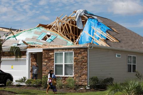 A girl removes personal belongings from her damaged home after a tornado spawned by Hurricane Dorian ripped apart her roof in Carolina Shores, North Carolina, U.S., September 6, 2019. PHOTO BY REUTERS/Jonathan Drake