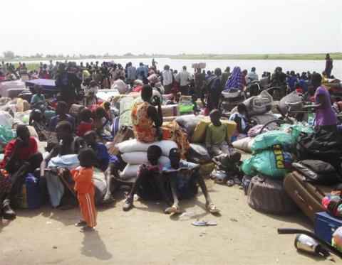 People displaced from fighting between the South Sudanese army and rebels, wait for boats to cross the Nile River, in Bor town, around 180 km (112 miles), northwest from the capital of Juba