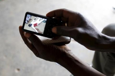 A man poses for a picture as he scrolls through pictures on his camera that he claims are images of Shi'ites who were injured or killed during recent clashes with the army in Zaria, Kaduna state, Nigeria, February 2, 2016. PHOTO BY REUTERS/Afolabi Sotunde