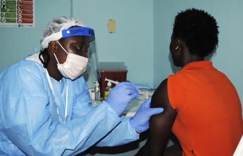 A health worker injects a woman with an Ebola vaccine during a trial in Monrovia, February 2, 2015. PHOTO BY REUTERS/James Giahyue