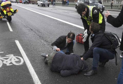 An injured person is assisted after an incident on Westminster Bridge in London, Britain, March 22, 2017. PHOTO BY REUTERS/Toby Melville