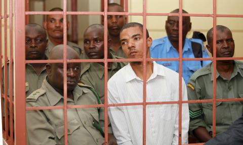 Jermaine John Grant (C, in white), a British citizen, is guarded by Kenyan police in court in Shanzu, near the Kenyan coastal city of Mombasa