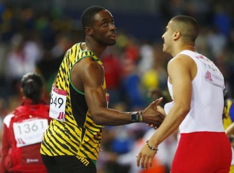 Gold medal winner Kemar Bailey-Cole (L) of Jamaica shakes hands with silver medal winnier Adam Gemili of England following the men's 100m final at the 2014 Commonwealth Games in Glasgow, Scotland