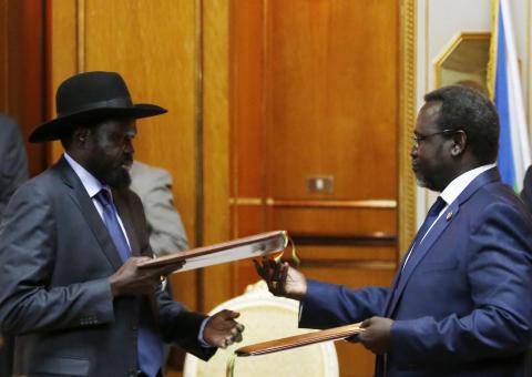 South Sudan's rebel leader Riek Machar (R) and South Sudan's President Salva Kiir (L) exchange signed peace agreement documents in Addis Ababa