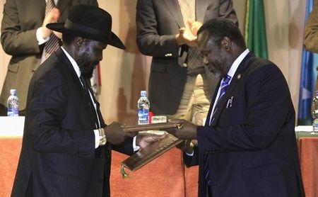 South Sudan's President Salva Kiir (L) and South Sudan's rebel commander Riek Machar exchange documents after signing a ceasefire agreement during the Inter Governmental Authority on Development (IGAD) Summit on the case of South Sudan in Ethiopia's capital Addis Ababa, Feburary 1, 2015. PHOTO BY REUTERS/Tiksa Negeri