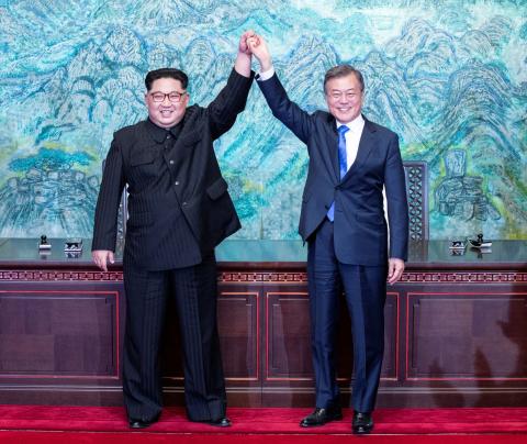 South Korean President Moon Jae-in and North Korean leader Kim Jong Un raise their hands at the truce village of Panmunjom inside the demilitarized zone separating the two Koreas, South Korea, April 27, 2018. PHOTO BY REUTERS/Korea Summit Press Pool