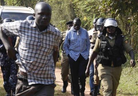 Opposition leader Kizza Besigye is escorted by Ugandan policemen to a police vehicle outside his house at the outskirts of Kampala, February 22, 2016. PHOTO BY REUTERS/Stringer