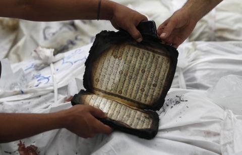 A partially burnt copy of Koran is seen next to dead members of the Muslim Brotherhood and supporters of Mursi at El Eyman mosque in Cairo