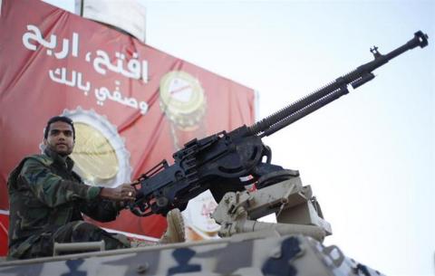 A member of the Libyan army guards the streets following yesterday's clashes in Benghazi