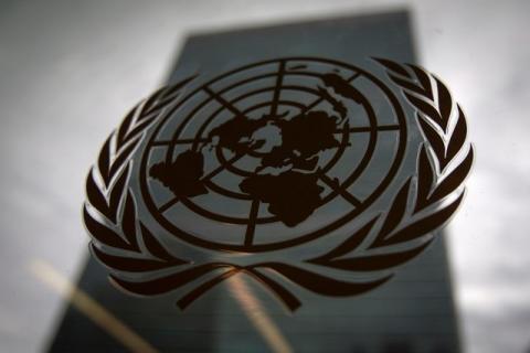 The United Nations headquarters building is pictured though a window with the UN logo in the foreground in the Manhattan borough of New York, August 15, 2014. PHOTO BY REUTERS/Carlo Allegri