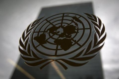 The United Nations headquarters building is pictured though a window with the UN logo in the foreground in the Manhattan borough of New York, August 15, 2014. PHOTO BY REUTERS/Carlo Allegri