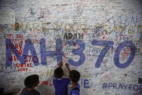 Children write messages of hope for passengers of missing Malaysia Airlines Flight MH370 at Kuala Lumpur International Airport (KLIA) outside Kuala Lumpur, June 14, 2014. PHOTO BY REUTERS/Samsul Said