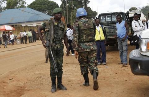 A peacekeeper serving in the United Nations Organization Stabilization Mission in the Democratic Republic of the Congo (MONUSCO) and a Congolese soldier stand guard in Beni in North Kivu province, October 23, 2014. PHOTO BY REUTERS/Kenny Katombe