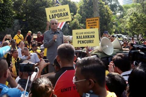 Malaysia's opposition coalition prime ministerial candidate Mahathir Mohamad speaks against a controversial proposal to redraw electoral boundaries outside near the Parliament House in Kuala Lumpur, Malaysia March 28, 2018. The sign (front R) reads: "Go out and vote, defeat the thief". PHOTO BY REUTERS/Stringer