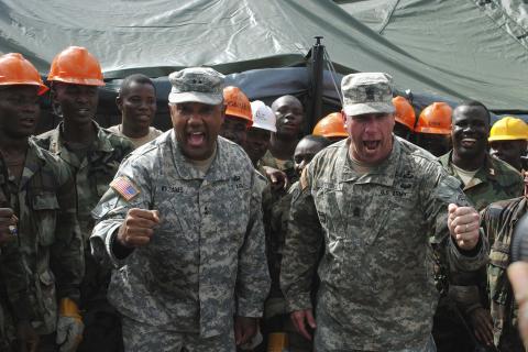 Major General Darryl Williams (L), head of U.S. troops in Liberia, and Sergeant Major Jeffery T. Stitzel cheer on Liberian soldiers at an Ebola treatment center, under construction in Tubmanburg