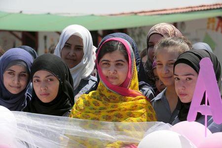Nobel Peace Prize laureate Malala Yousafzai (C) poses with girls for a picture at a school for Syrian refugee girls, built by the NGO Kayany Foundation, in Lebanon's Bekaa Valley, July 12, 2015. PHOTO BY REUTERS/Jamal Saidi