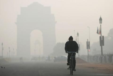 A man rides his bicycle in front of the India Gate shrouded in smog in New Delhi, India, December 26, 2018. PHOTO BY REUTERS/Adnan Abidi