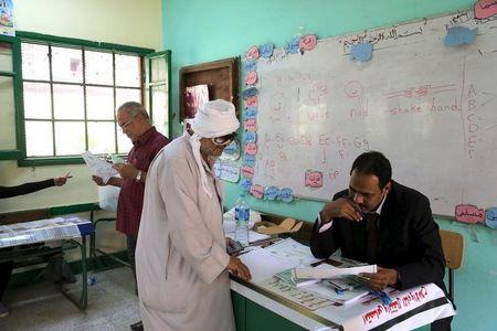 A man gets help to read names of candidates before casting his vote during parliamentary election at a voting centre in Giza governorate, Egypt, October 19, 2015. PHOTO BY REUTERS/Asmaa Waguih