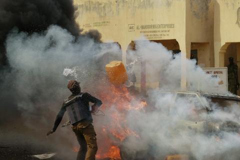 A man throws a container of water towards a burning car after a bomb explosion barely a few minutes after Nigerian President Goodluck Jonathan left Gombe stadium, February 2, 2015. PHOTO BY REUTERS/Afolabi Sotunde