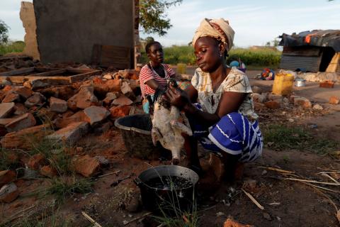 Maria Jofresse, 25, watches her mother Ester Thoma preparing food beside their damaged house in the aftermath of Cyclone Idai, in the village of Cheia, which means "Flood" in Portuguese, near Beira, Mozambique April 4, 2019. PHOTO BY REUTERS/Zohra Bensemra