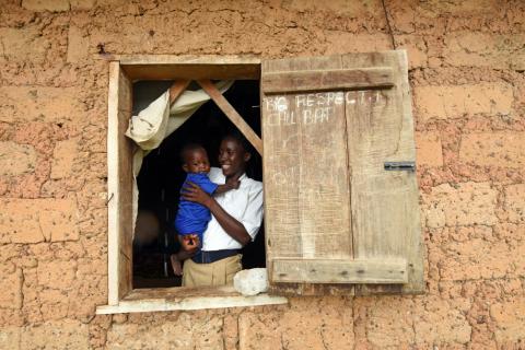 Mariatu Sesay, 15, carries her daughter as she looks out the window in a countryside village of Sierra Leone, July 11, 2019. PHOTO BY REUTERS/Cooper Inveen