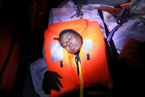 Mata, 23, who's from Nigeria, tries to recover after fainting during a rescue operation of 104 sub-Saharan migrants aboard a raft by the Spanish NGO Proactiva Open Arms, in the central Mediterranean Sea, 24 miles north of the Libyan coastal city of Sabratha, January 27, 2017. PHOTO BY REUTERS/Giorgos Moutafis