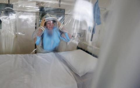 Matron Breda Athan demonstrates putting on the protective suit which would be used if it becomes necessary to treat patients suffering from Ebola