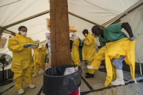 Medical staff working with Medecins sans Frontieres (MSF) put on their protective gear before entering an isolation area at the MSF Ebola treatment centre in Kailahun