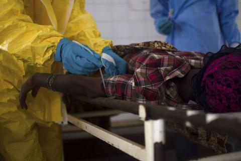 Medical staff take a blood sample from a suspected Ebola patient at the government hospital in Kenema