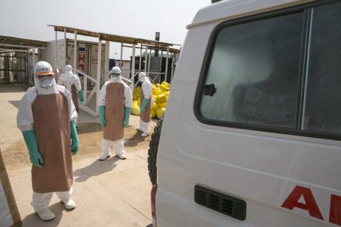 Healthcare workers prepare to disinfect an ambulance transporting a newly admitted Ebola patient at the entrance to the Save the Children Kerry Town Ebola treatment centre outside Freetown, Sierra Leone, December 22, 2014. REUTERS/Baz Ratner