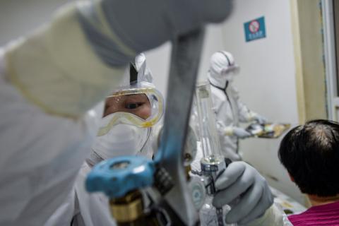 A medical worker in protective suit replaces an oxygen tank for a patient at a community health service center, which has an isolated section to receive patients with mild symptoms caused by the novel coronavirus and suspected patients of the virus, in Qingshan district of Wuhan, Hubei province, China, February 8, 2020. PHOTO BY REUTERS