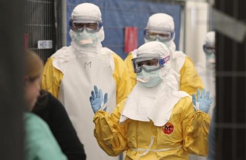 Volunteers for Medecins Sans Frontieres (MSF), or Doctors Without Borders, receive training on how to handle personal protective equipment during courses in Brussels October 15, 2014. PHOTO BY REUTERS/Francois Lenoir