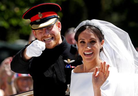 Britain's Prince Harry gestures next to his wife Meghan as they ride a horse-drawn carriage after their wedding ceremony at St George's Chapel in Windsor Castle in Windsor, Britain, May 19, 2018. PHOTO BY REUTERS/Damir Sagolj