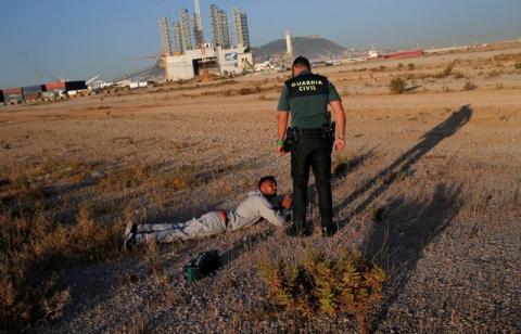 A migrant intercepted aboard a dinghy off the coast in the Strait of Gibraltar, pleads as he is detained by a Spanish civil guard after escaping from a rescue boat after arriving at the port of Algeciras, southern Spain, July 6, 2018. PHOTO BY REUTERS/Jon Nazca