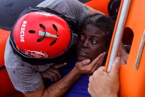 A crew member of NGO Proactiva Open Arms rescue boat embraces African migrant in central Mediterranean Sea. PHOTO BY REUTERS/Juan Medina