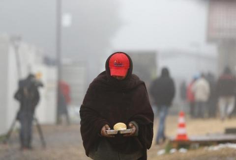 A migrant balances his food as he walks through a temporary registration centre in the village of Schwarzenborn, northeast of Frankfurt, Germany, October 15, 2015. PHOTO BY REUTERS/Kai Pfaffenbach