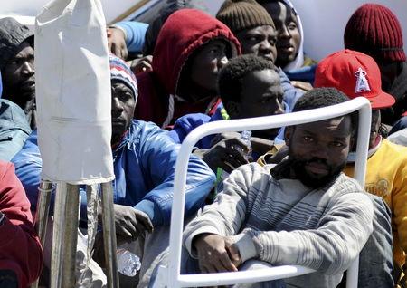 Migrants wait before disembarking from a Coast Guard boat as they arrive in the Sicilian harbour of Palermo, April 15, 2015. PHOTO BY REUTERS/Guglielmo Mangiapane