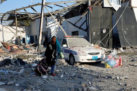 A migrant picks up her belongings from among rubble at a detention centre for mainly African migrants that was hit by an airstrike in the Tajoura suburb of the Libyan capital of Tripoli, Libya, July 3, 2019. PHOTO BY REUTERS/Ismail Zitouny