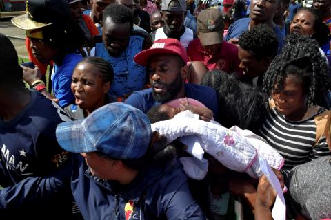 A migrant from Cameroon holds his baby while trying to enter the Siglo XXI immigrant detention center to request humanitarian visas, issued by the Mexican government, to cross the country towards the United States, in Tapachula, Mexico, June 27, 2019. PHOTO BY REUTERS/Jose Torres