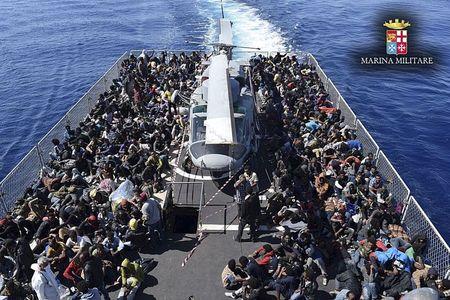 Migrants sit in Italian navy ship Vega during a rescue operation off the coast of Sicily, in this handout picture courtesy of the Italian Marina Militare (Marine Military) released on May 4, 2015. PHOTO BY REUTERS/Marina Militare