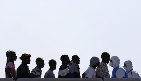 Migrants wait to disembark from the Italian Navy vessel Cigala Fulgosi in the Sicilian harbour of Augusta, Italy, September 3, 2015. PHOTO BY REUTERS/Antonio Parrinello