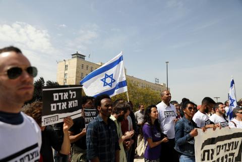 African migrants and Israeli activists demonstrate in support of the new agreement with the U.N. refugee agency to relocate thousands of African migrants, outside Israeli Prime Minister office in Jerusalem April 3, 2018. The placard in Hebrew reads "Every Human is a Human". PHOTO BY REUTERS/Ammar Awad